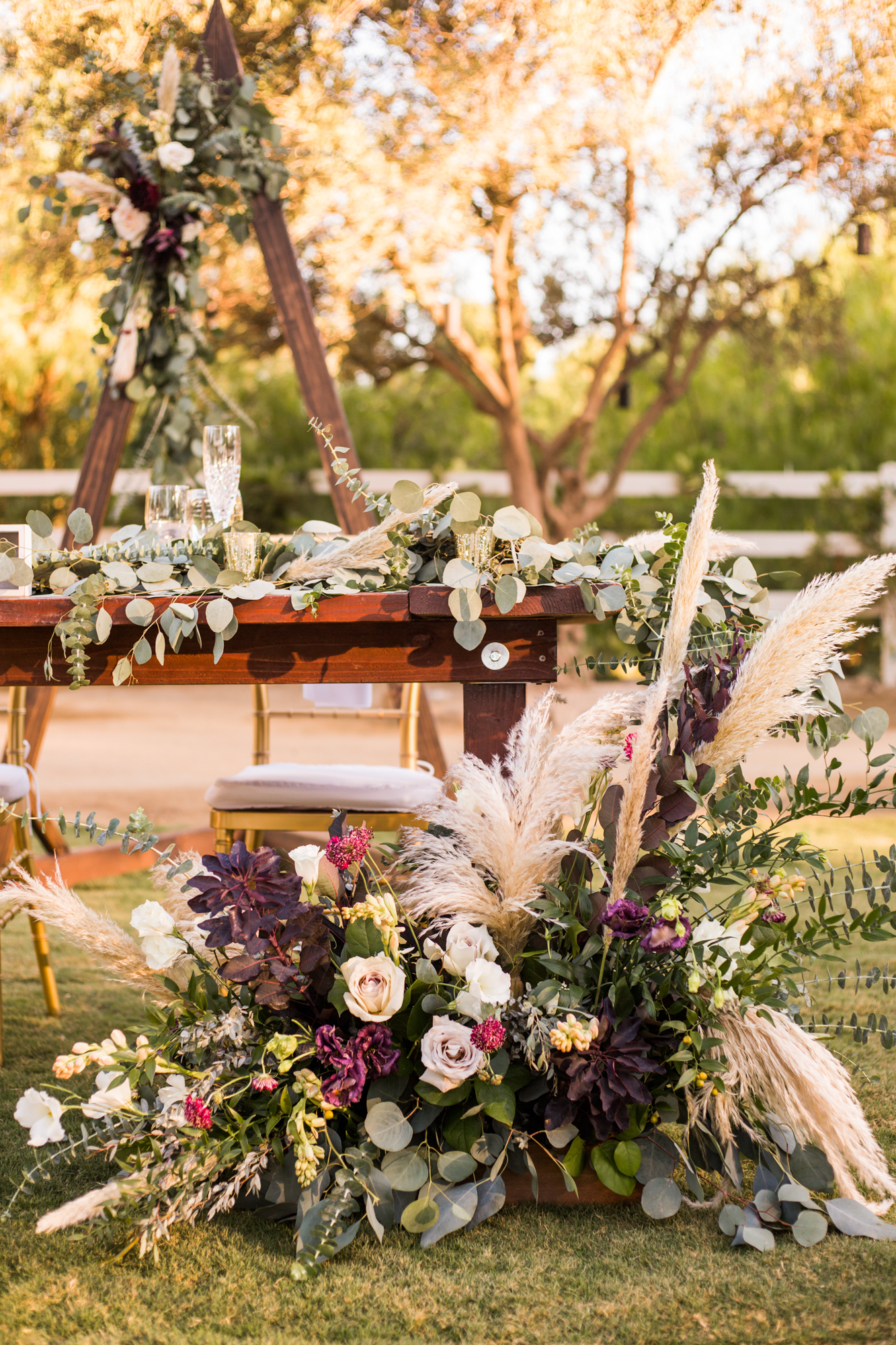 Fall themed sweetheart table florals with pampas grass